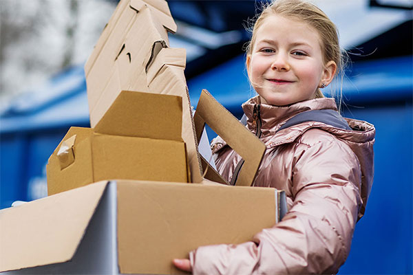 Girl with cardboard to put in recycling
