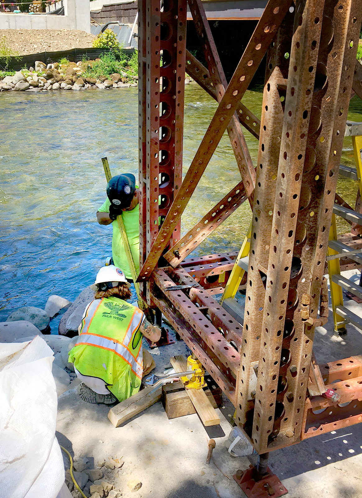 Construction workers repairing the supports of the bridge