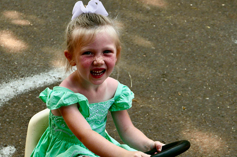 Girl rides pedal push car on Safety Street at the Clackamas County Fair