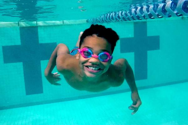 Young boy swimming underwater in a pool