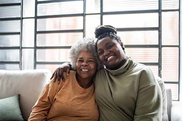 Two family members hug on a couch