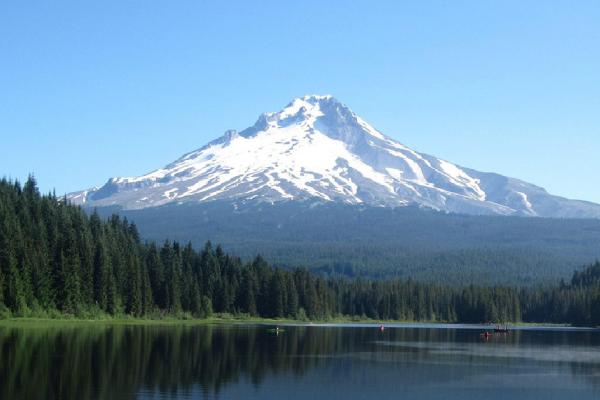 Lake surrounded by trees with Mt. Hood in the distance.