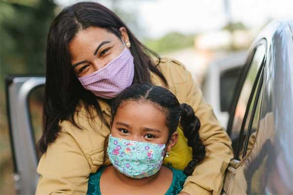 Mother and daughter wear masks to prevent spread of COVID-19