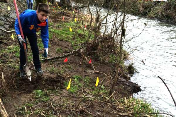 Young man cleans up shore of river