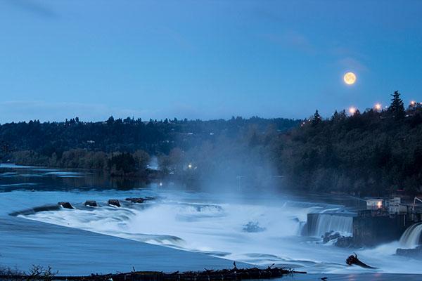 Willamette falls at dusk with moon visible and mist