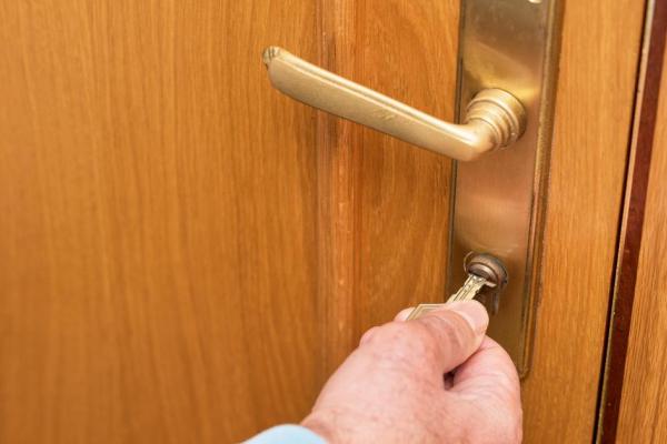Senior man unlocks door