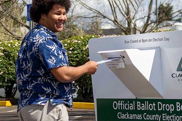 Young man dropping off a ballot