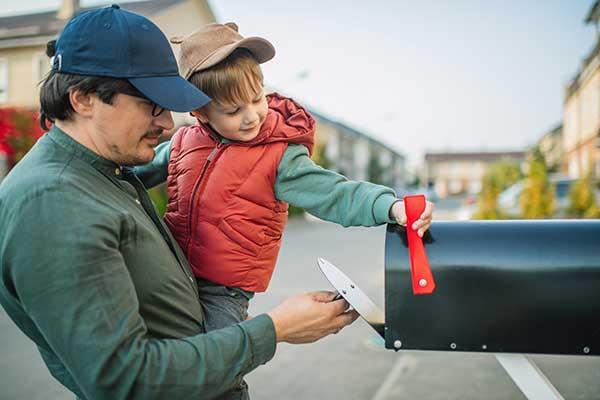 Father and son check mailbox