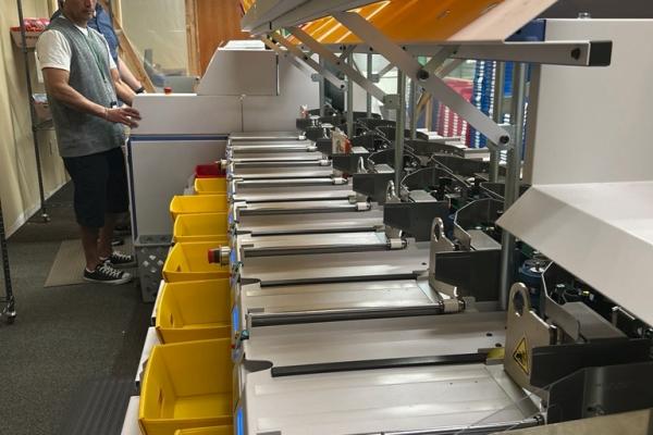 Elections staff operate the new mail ballot sorter