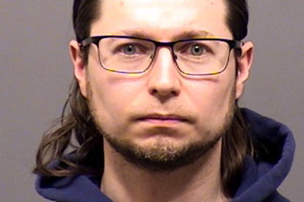 Mugshot of person with blue hoodie and long hair