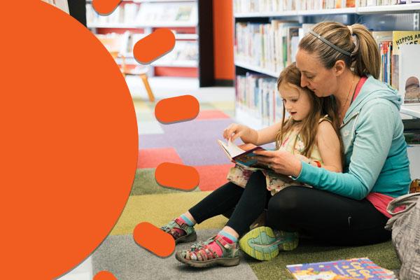 Mother and daughter reading in a library