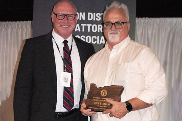 Bill Stewart holding his award, standing next to John Wentworth
