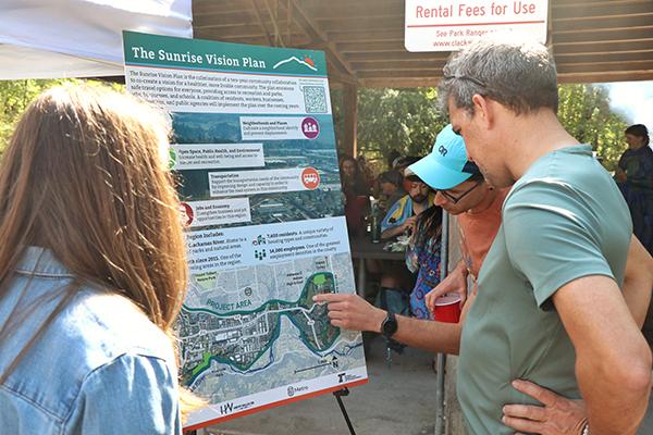 people looking at a sign, learning about the Sunrise Corridor project