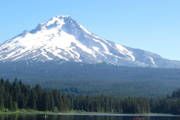 Lake surrounded by trees with Mt. Hood in the distance.