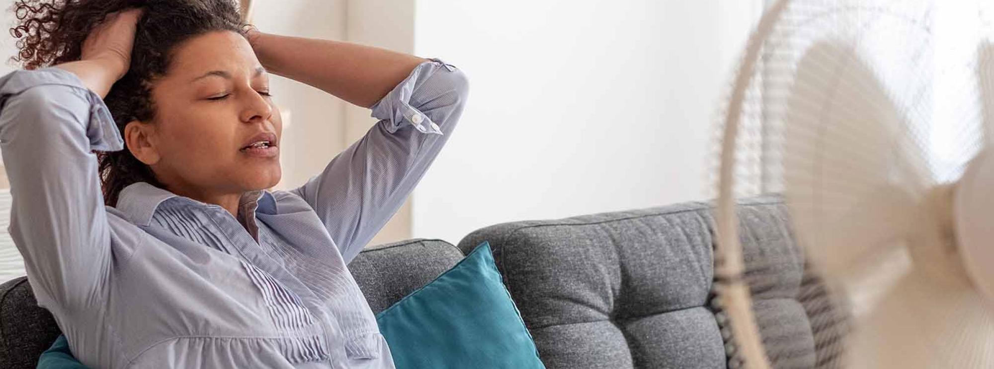 Woman in front of fan cools off during extreme heat