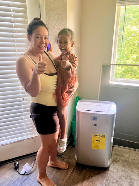 Sunrise Corridor residents pose happily with their newly installed cooling device as part of the Sunrise Corridor Community Heat Mitigation Program