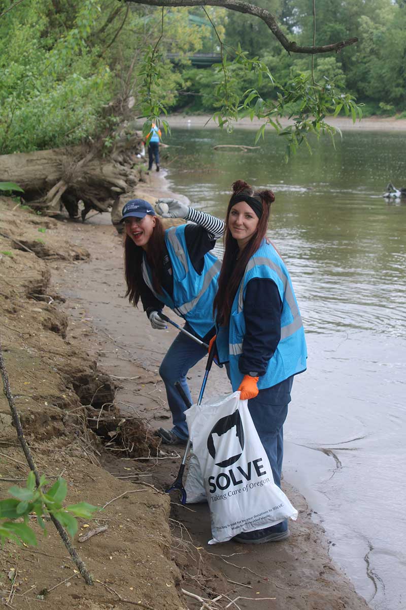 volunteers picking up litter along Willamette River